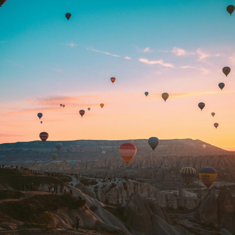 Colorful hot air balloons soaring over Cappadocia at sunrise, Turkey.